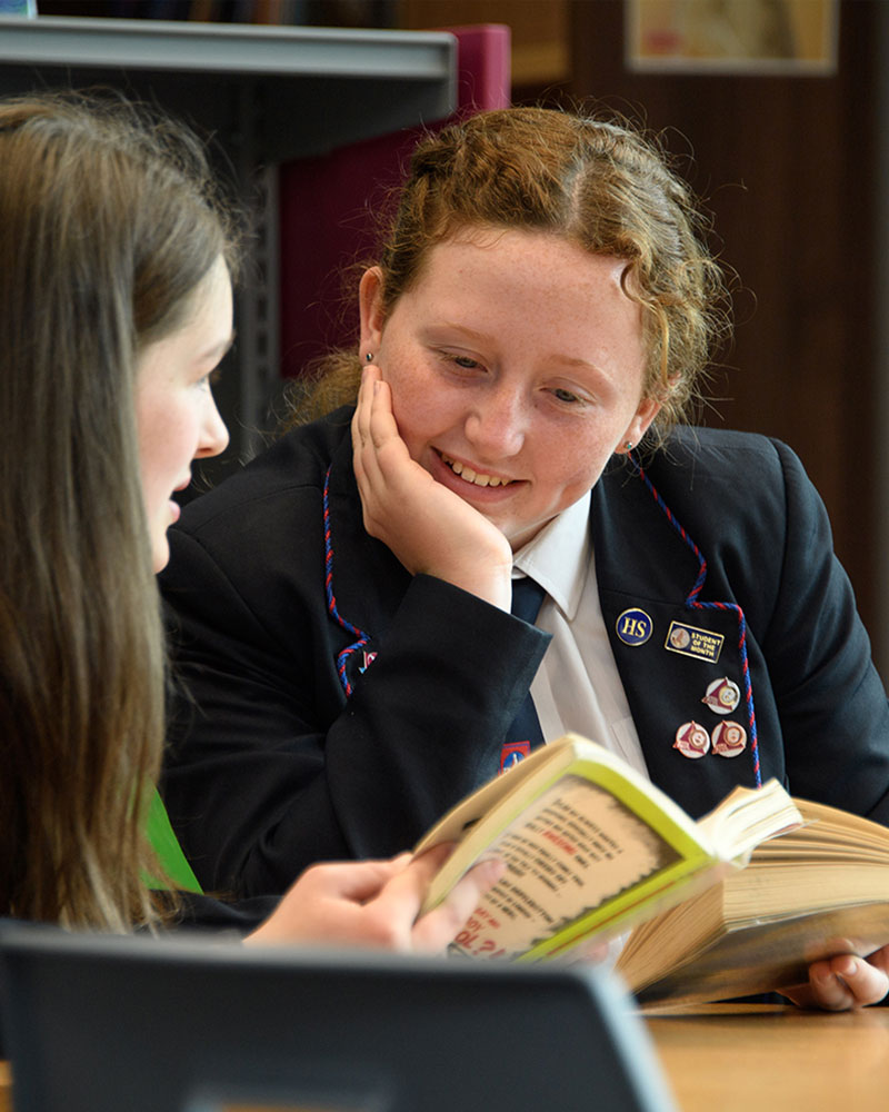 Girls in library reading together
